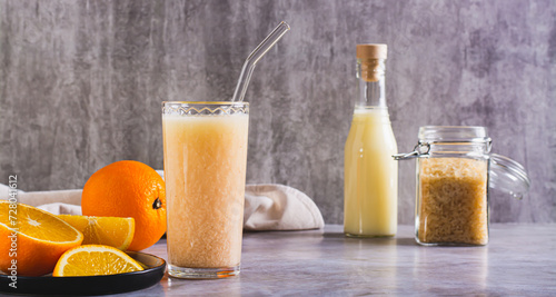 Vegetarian smoothie made from rice milk and orange in a glass on the table web banner