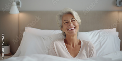 Portrait of happy fresh beautiful senior woman waking up after healthy sleep in cozy comfortable bed