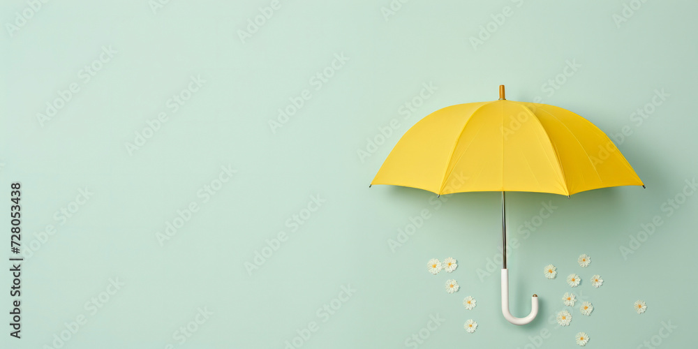 Yellow umbrella isolated on a green background with white flower petals falling next to it. - obrazy, fototapety, plakaty 