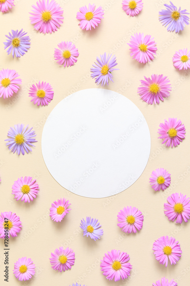 Stylish border frame of pink and purple flower aster on beige background with blank paper sheet. Spring and summer greeting card template. Flat lay, top view, mockup. Aesthetic floral pattern.