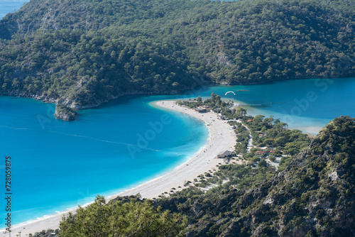 Oludeniz Beach's panoramic view highlights the lush hills bordering the vibrant turquoise sea.