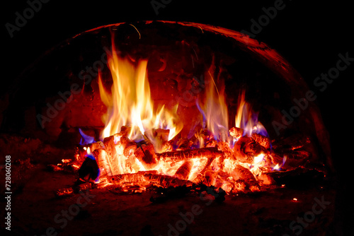 Wood logs are engulfed in flames  radiating heat and light.