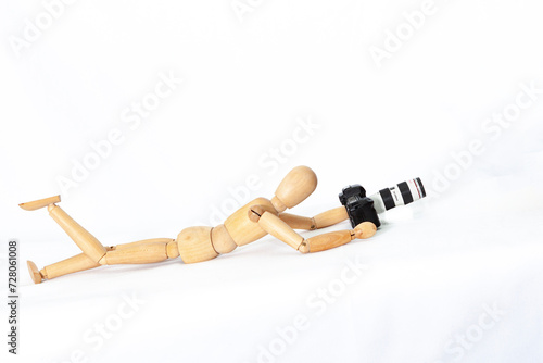 Wooden figure of a mannequin with a camera on a white isolated background... 