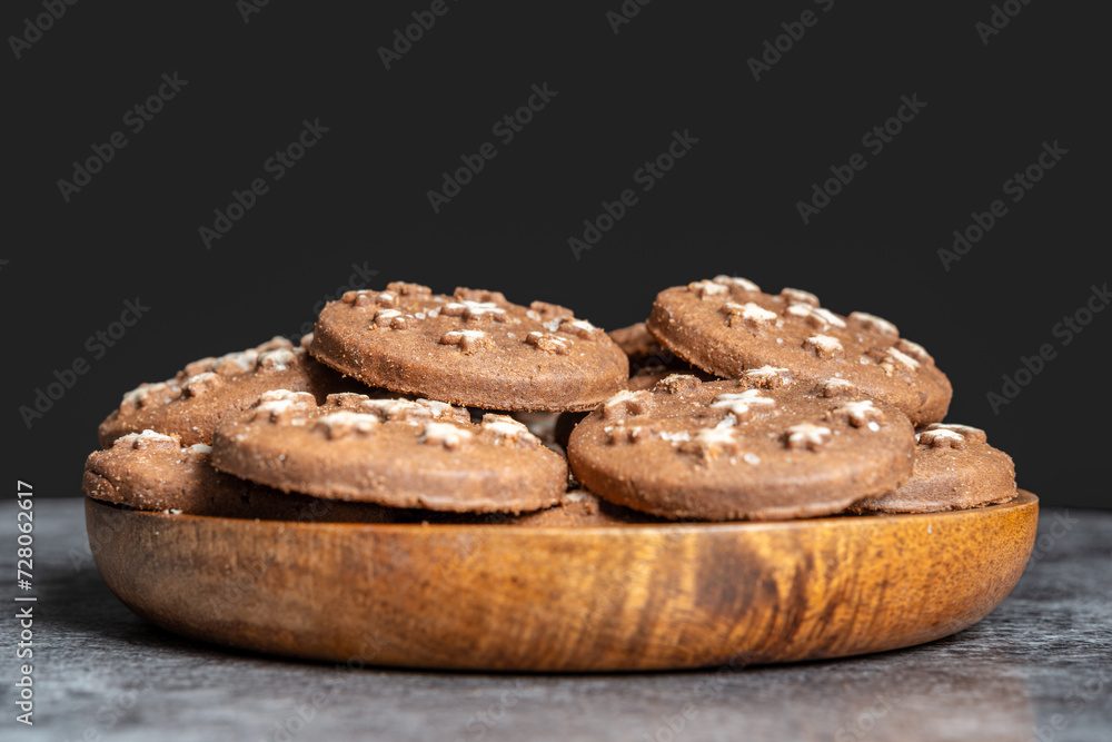 Delicious sweet cocoa cookies biscuits on a wooden plate