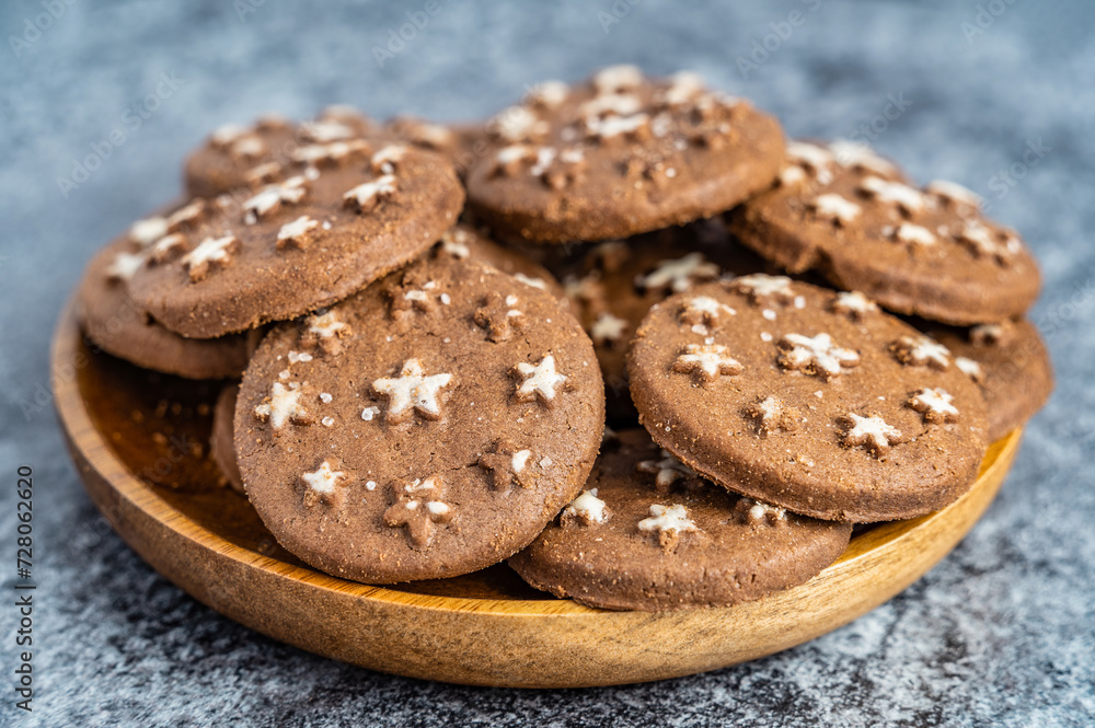 Delicious sweet cocoa cookies biscuits on a wooden plate