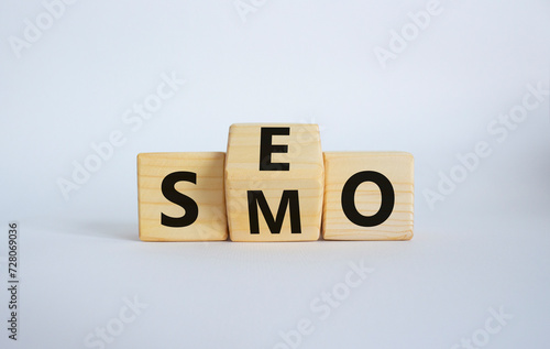 SEO vs SMO symbol. Wooden cubes with words SMO and SEO. Beautiful white background. SEO vs SMO and business concept. Copy space