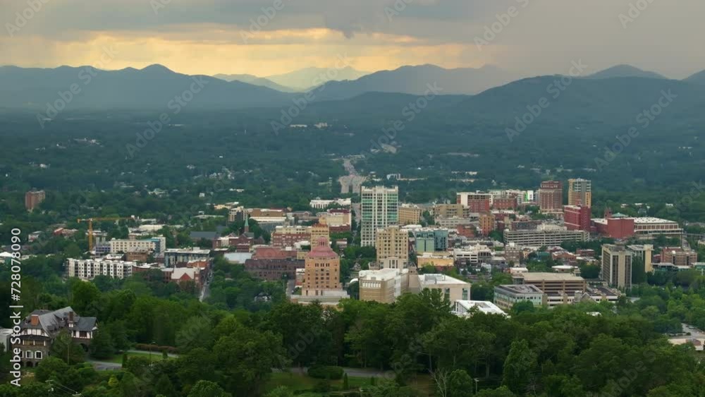 USA travel destination landscape. Panoramic view of North Carolina Appalachian city Asheville with downtown architecture and Blue Ridge Mountain hills in distance at sunset