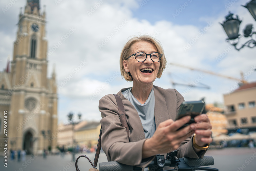 Fototapeta premium Woman with electric kick scooter use mobile phone smartphone send sms