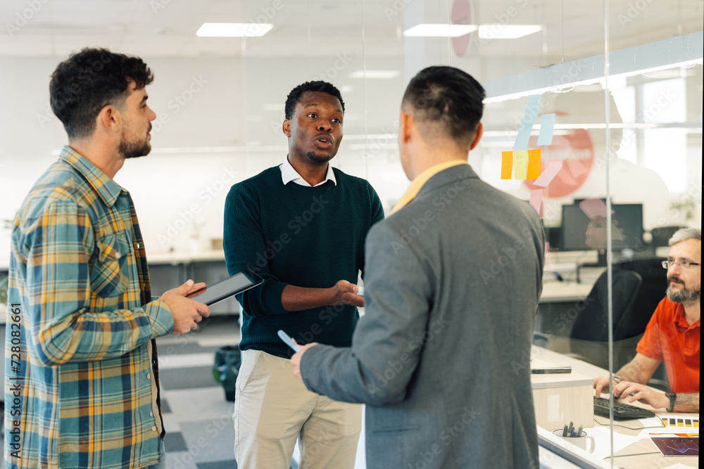 Obraz premium Multiracial business team writing their ideas on a colorful stickers