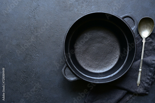 Culinary background with empty cast iron pan , napkin and spoon. Top view with copy space.