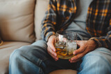 Alcoholic sitting on the sofa with a glass of alcohol, alcoholism concept. Background with selective focus