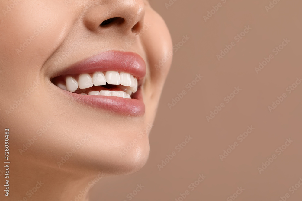 Fototapeta premium Woman with clean teeth smiling on beige background, closeup. Space for text