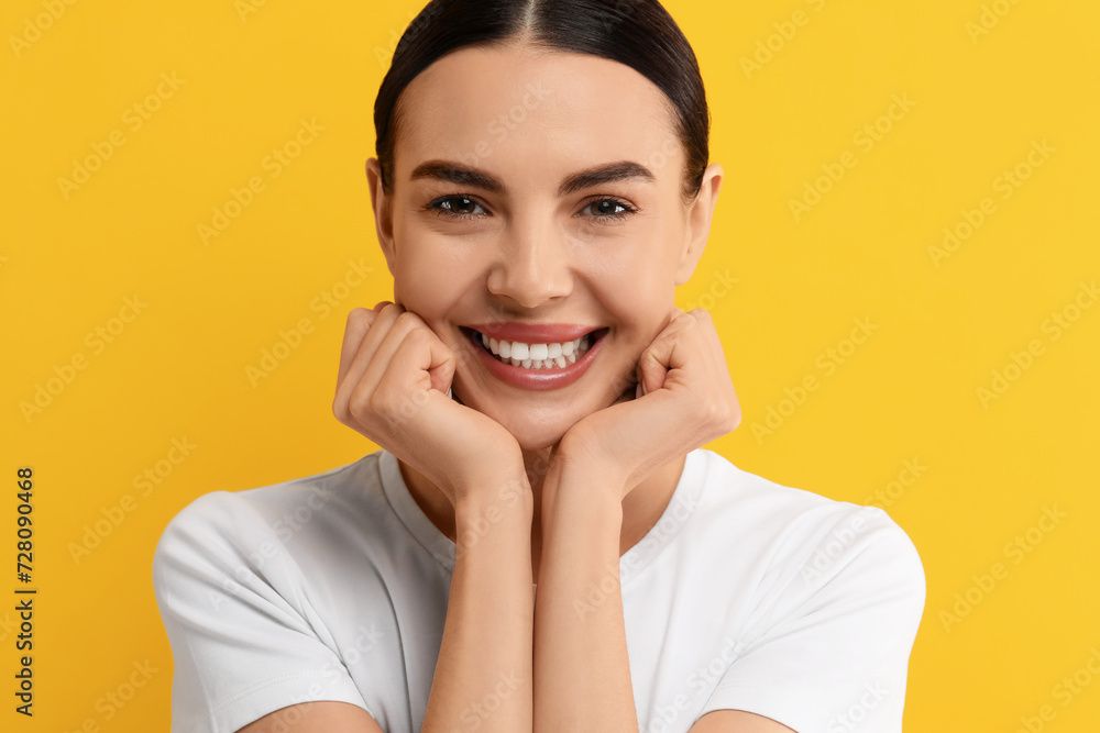 Beautiful woman with clean teeth smiling on yellow background Beautiful woman with clean teeth smiling on yellow background
