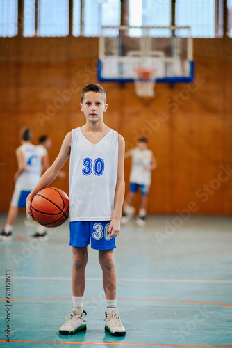 Portrait of a boy with a basketball on court during the training.