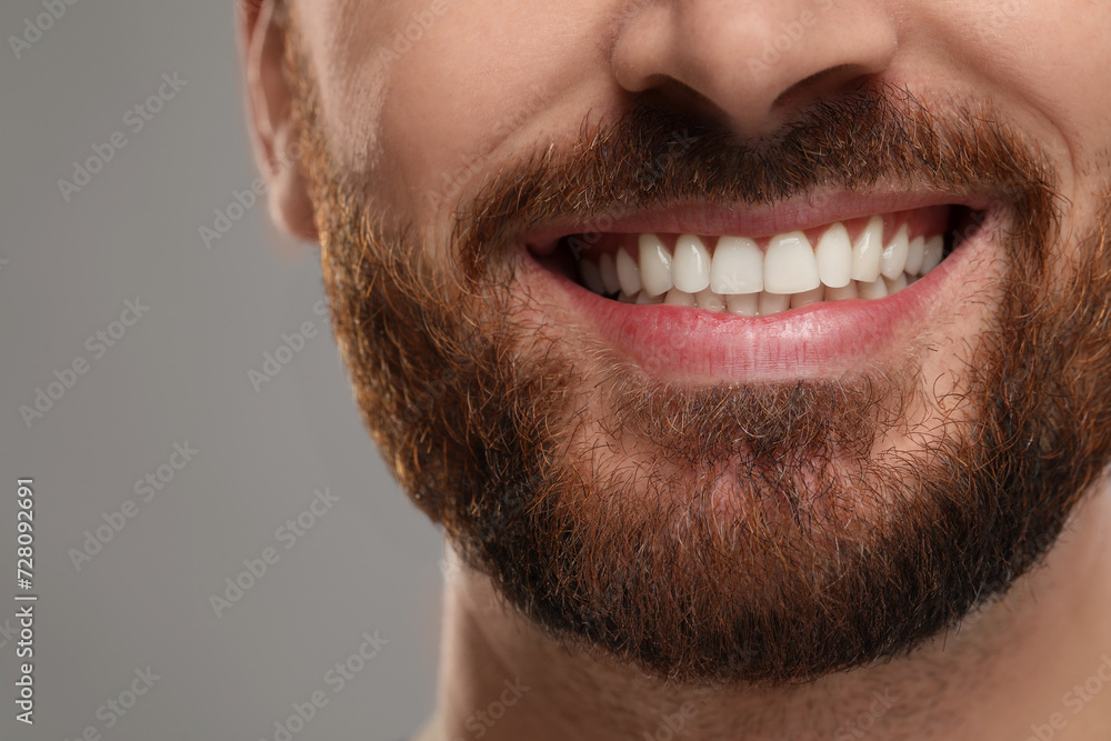 Smiling man with healthy clean teeth on grey background, closeup Smiling man with healthy clean teeth on grey background, closeup