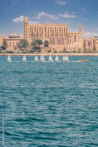 Majestic Majorca Cathedral Overlooking a Regatta of Sailing Dinghies on Azure Waters photo