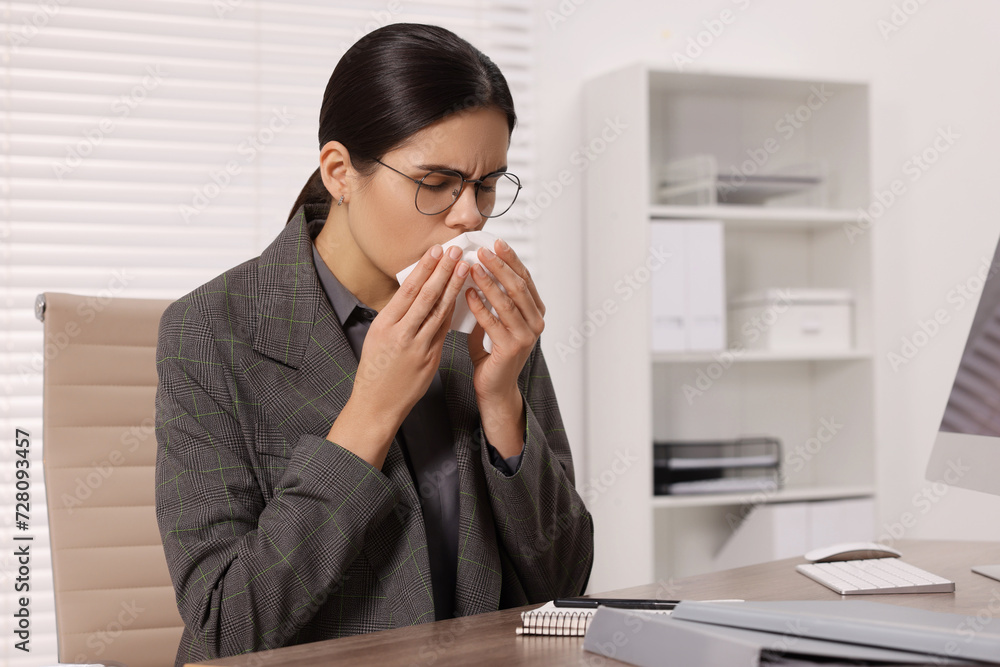 Woman with tissue coughing at table in office. Cold symptoms Woman with tissue coughing at table in office. Cold symptoms