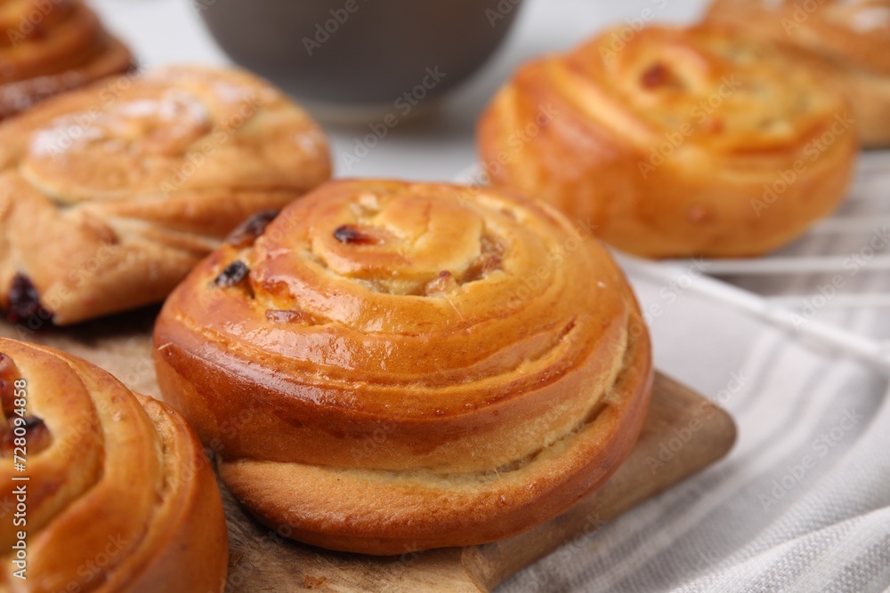 Delicious rolls with raisins on table, closeup. Sweet buns