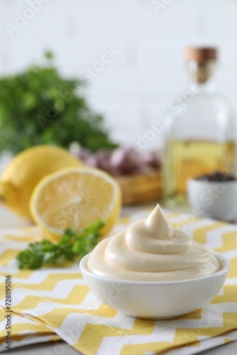Tasty mayonnaise sauce in bowl on table. Space for text