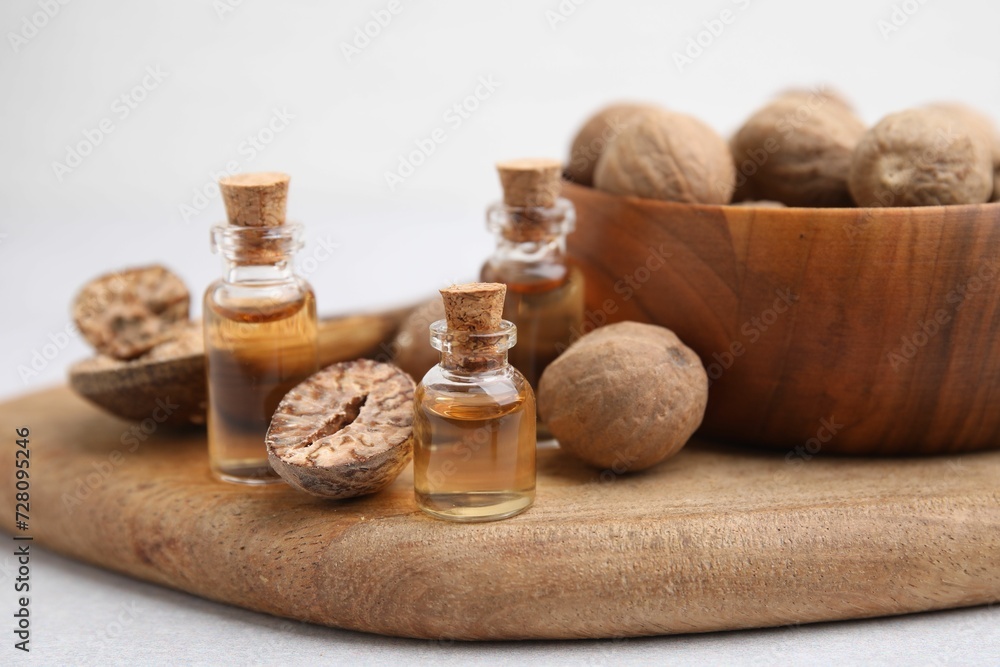 Nutmeg essential oil and nuts on light table Nutmeg essential oil and nuts on light table