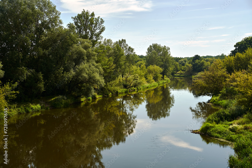 rural landscape with the Warta river and forest during summer