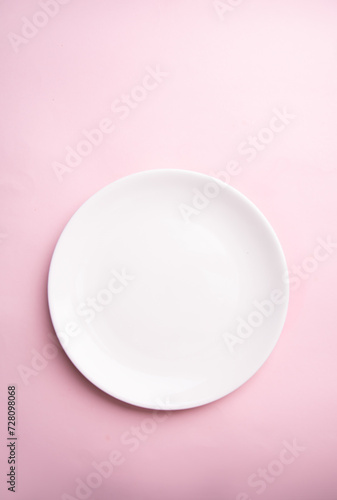 White flat plate on a light pink background. View from above