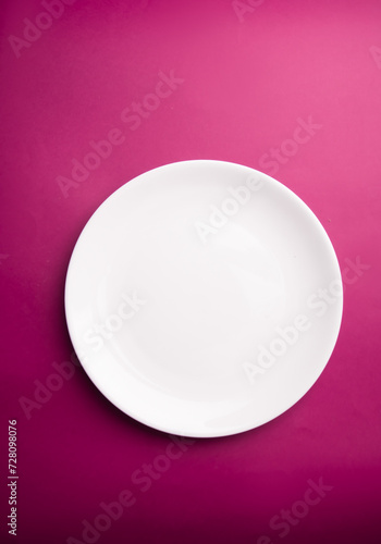 White flat plate on a purple background. View from above