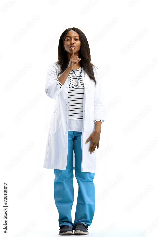 A full-length female doctor, on a white background, shows a sign of silence A full-length female doctor, on a white background, shows a sign of silence