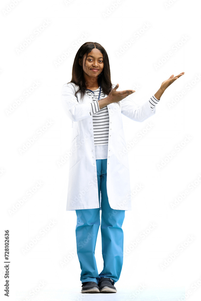 A female doctor, on a white background, in full height, points to the side A female doctor, on a white background, in full height, points to the side