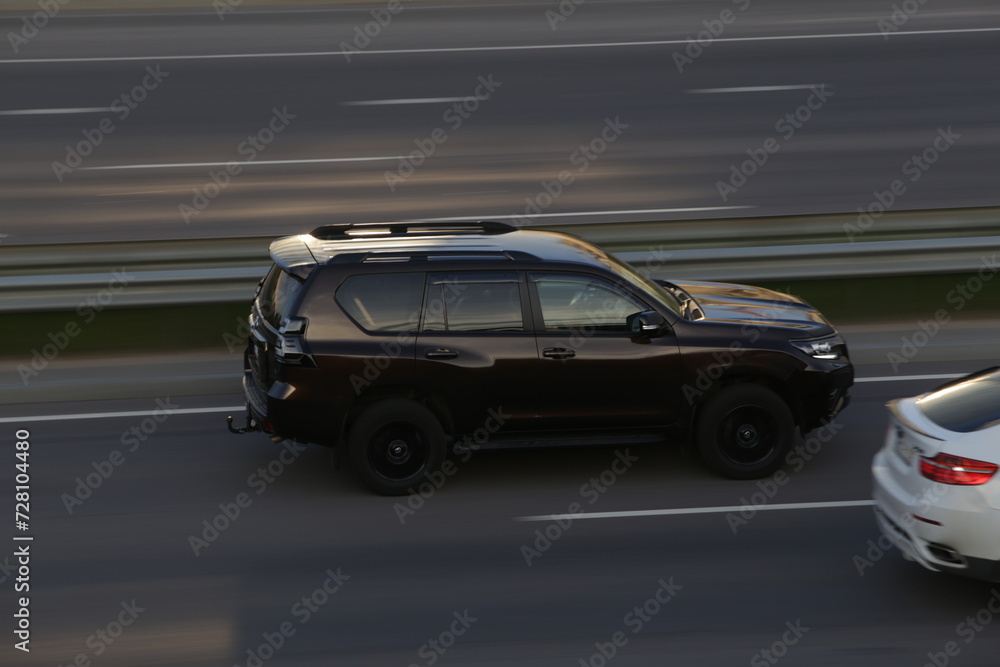 Black SUV with black rims driving on highway
