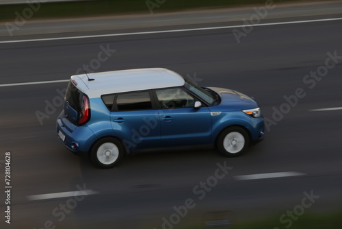 Modern blue electric vehicle driving throug highway