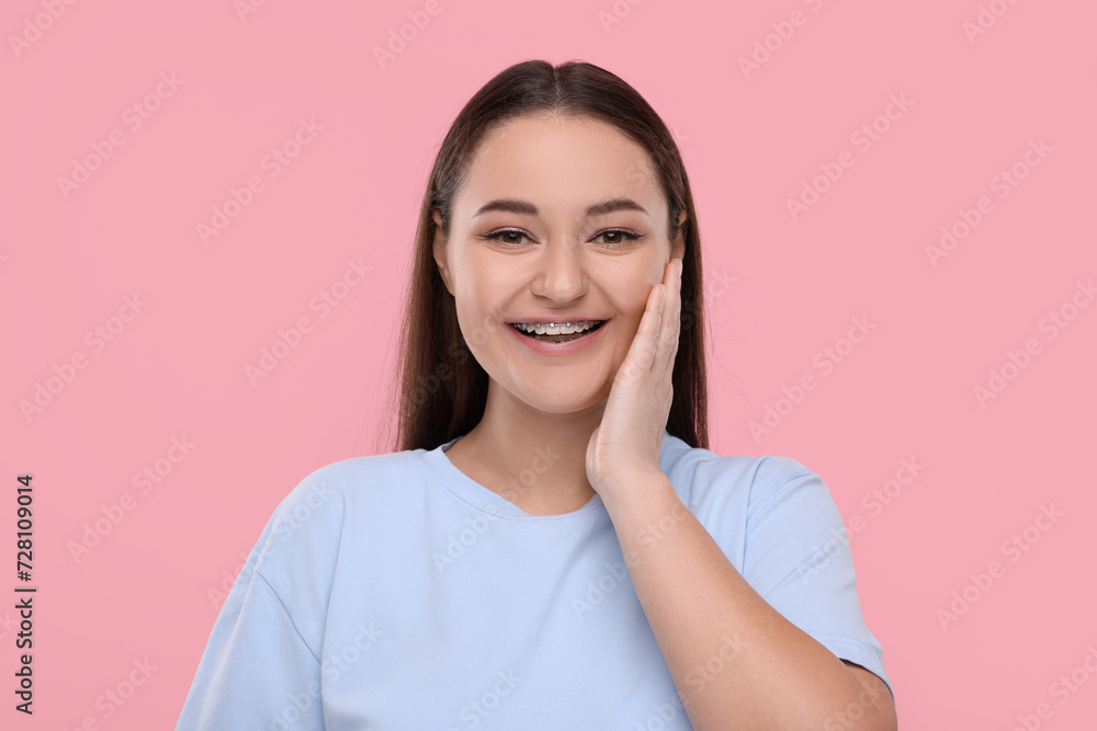Smiling woman with dental braces on pink background Smiling woman with dental braces on pink background
