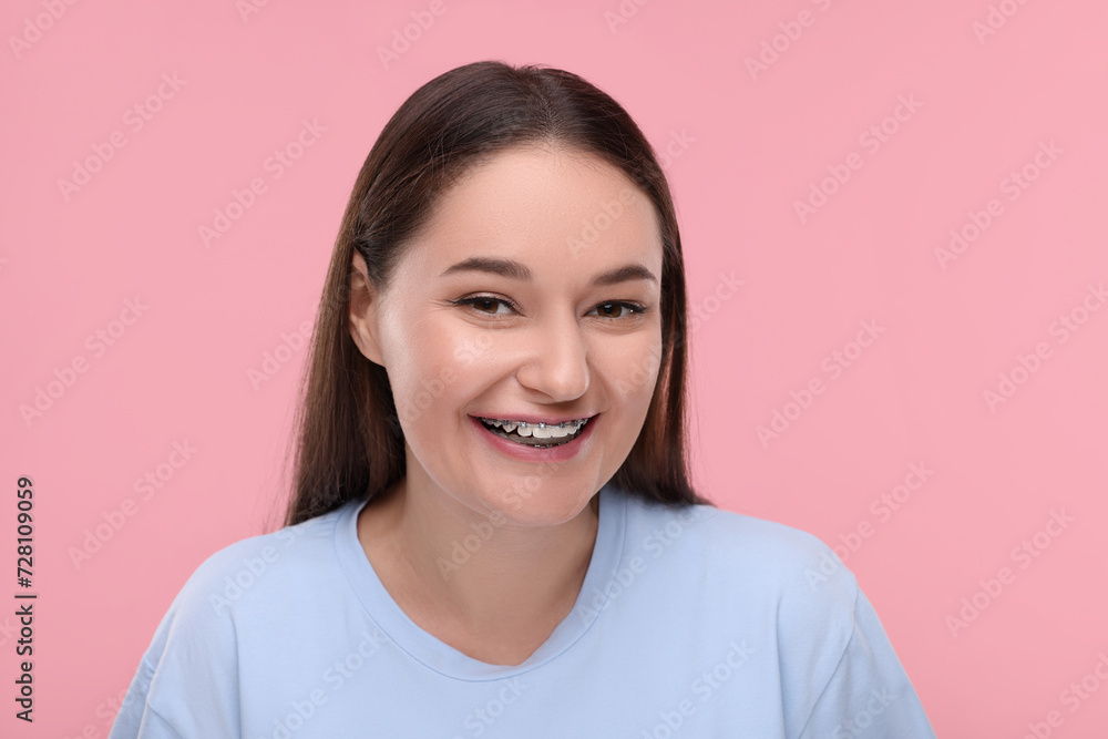 Smiling woman with dental braces on pink background Smiling woman with dental braces on pink background