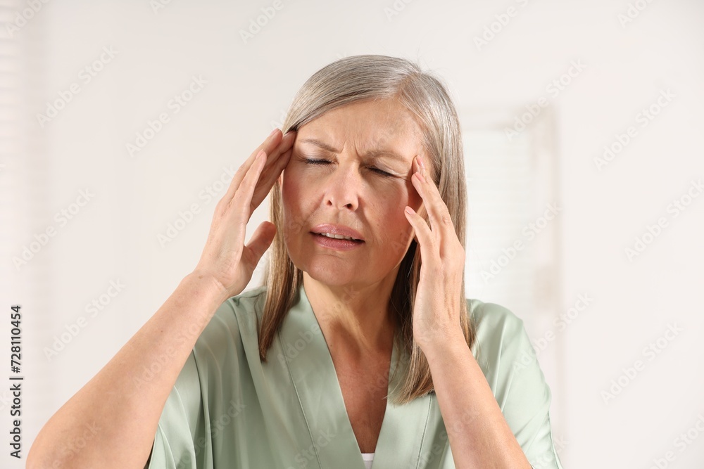 Menopause. Woman suffering from headache in bathroom Menopause. Woman suffering from headache in bathroom