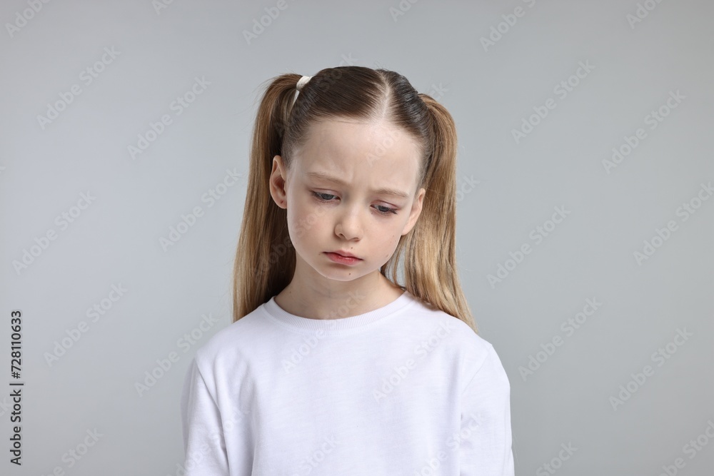 Portrait of sad girl on light grey background Portrait of sad girl on light grey background