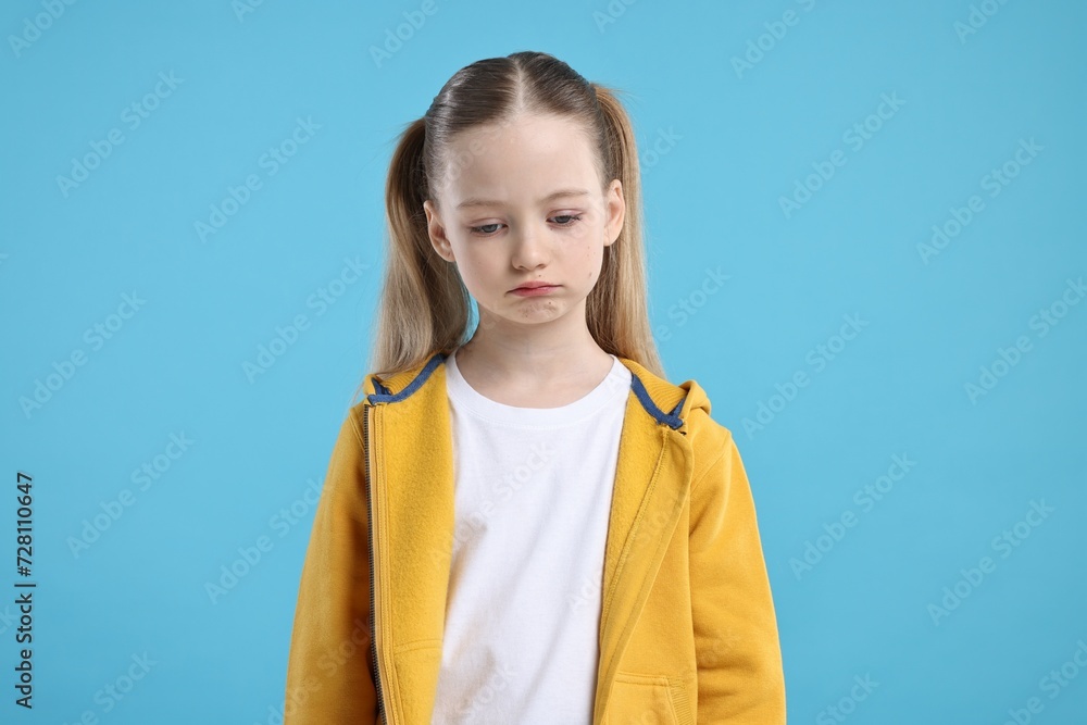 Portrait of sad girl on light blue background Portrait of sad girl on light blue background