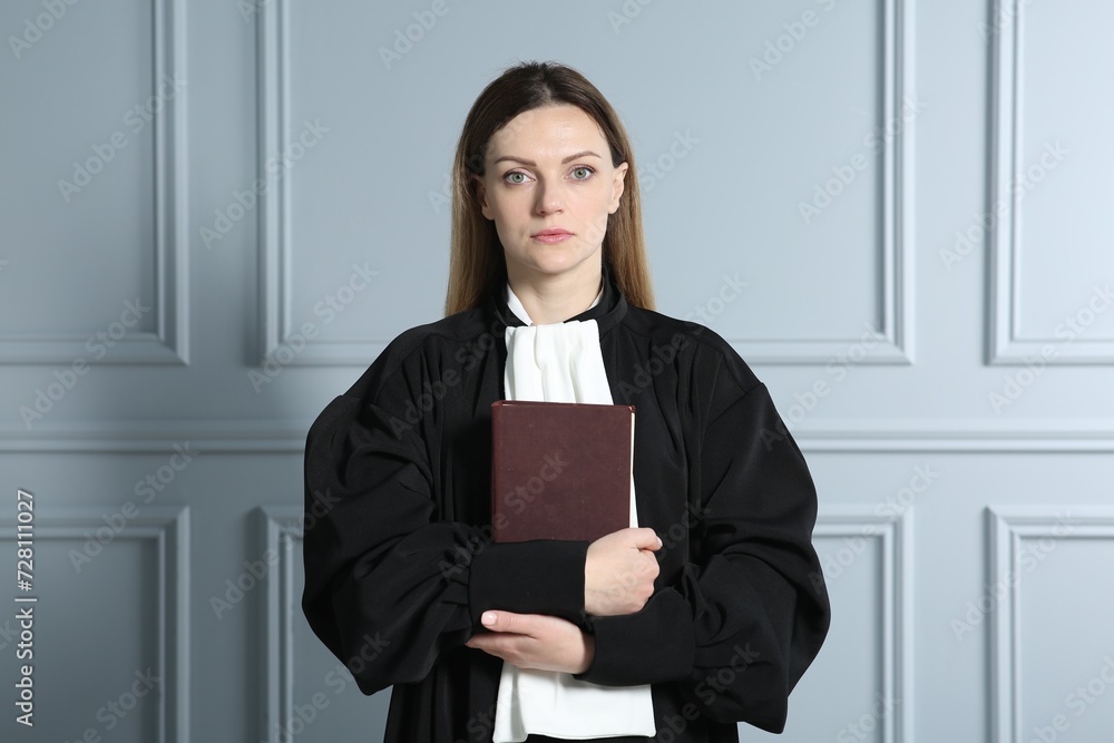 Portrait of judge with book near grey wall Portrait of judge with book near grey wall