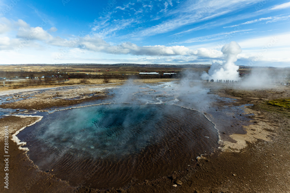 Vista panorámica de Geysir mientras un géiser estalla ante la atenta mirada de los turistas Vista panorámica de Geysir mientras un géiser estalla ante la atenta mirada de los turistas