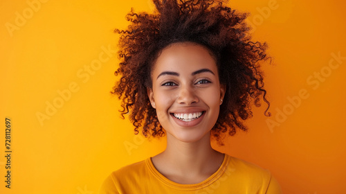 A happy, successful woman in a casual outfit, smiling confidently at the camera against a subtle orange background. She exudes a sense of fulfillment and self-assurance. photo