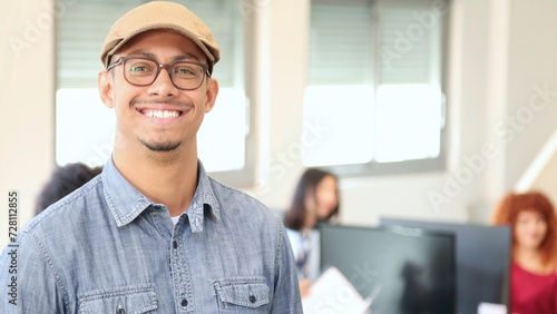 portrait of smiling young latin office worker man in an office