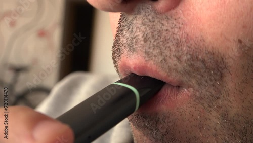 Close up view of man smoking vapor from a vape or electronic cigarette 4k video photo
