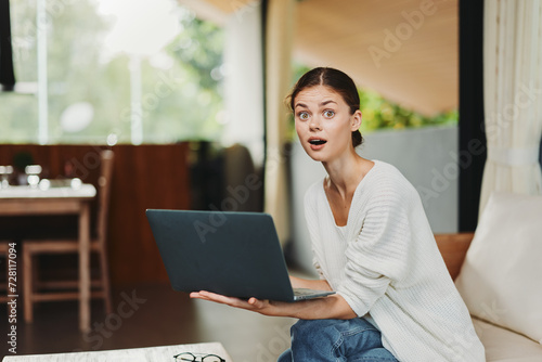 Smiling Woman Enjoying Online Shopping on Her Laptop in the Comfort of Her Cozy Living Room Free Download Smiling Woman Enjoying Online Shopping on Her Laptop in the Comfort of Her Cozy Living Room - GFXLoad