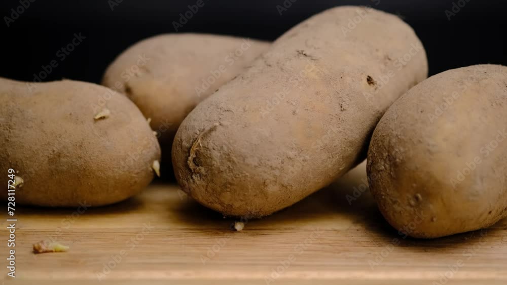 There are a lot of potatoes on a wooden shelf. Unpeeled potatoes There are a lot of potatoes on a wooden shelf. Unpeeled potatoes