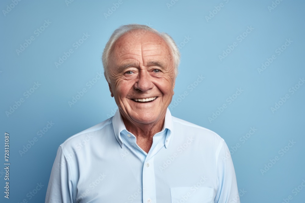 Portrait of happy senior man looking at camera and smiling against blue background Portrait of happy senior man looking at camera and smiling against blue background