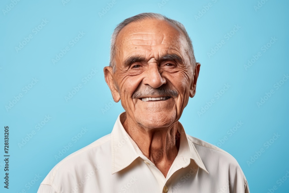 Portrait of a smiling senior man looking at camera on blue background Portrait of a smiling senior man looking at camera on blue background