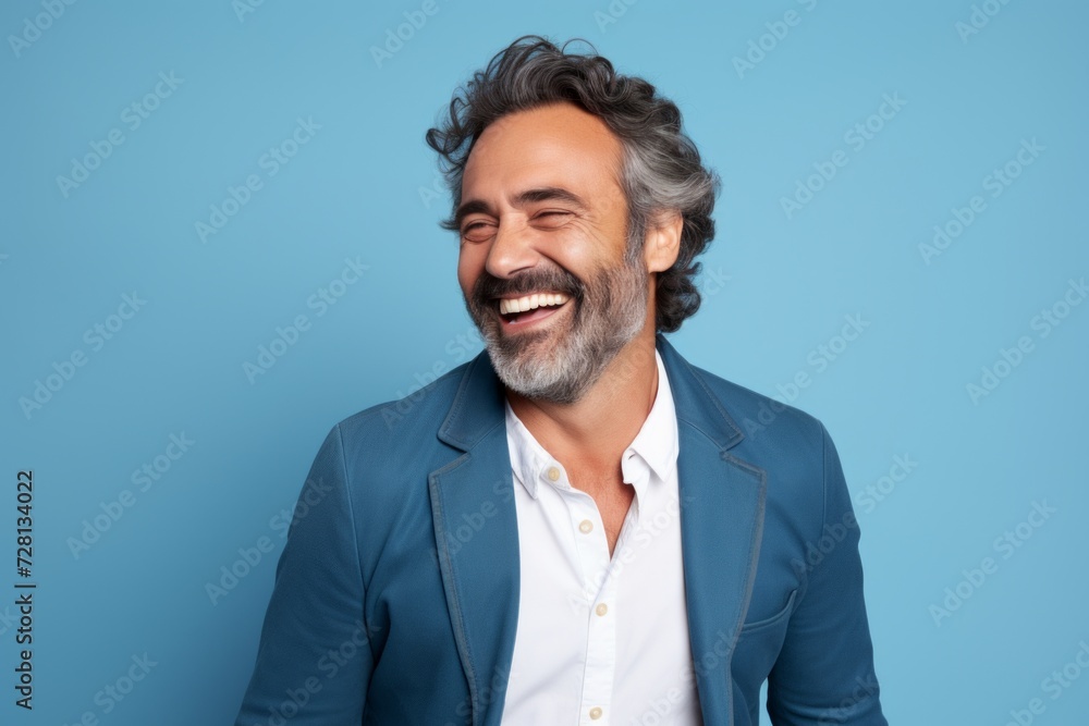 Handsome middle aged man laughing and looking at camera isolated over blue background Handsome middle aged man laughing and looking at camera isolated over blue background
