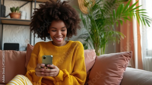 Happy relaxed young woman sitting on couch using cell phone, smiling lady laughing holding smartphone, looking at cellphone enjoying doing online ecommerce shopping in mobile apps or watchin photo
