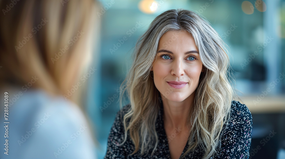 Fototapeta premium Women Sitting at a Table Engaged in Conversation