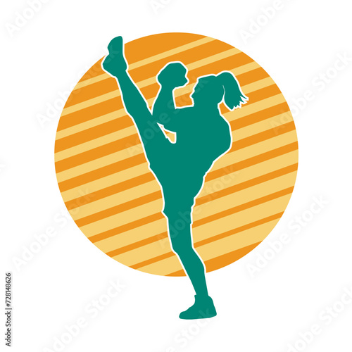 Silhouette of a female kickboxer athlete in action pose. Silhouette of a sporty woman doing kicking pose.
