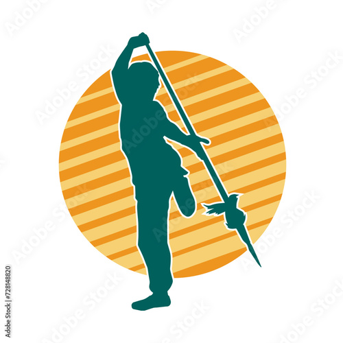 Silhouette of a martial art person in action pose with spear weapon. Silhouette of a fighter male using spear weapon in battle pose.